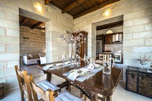 comedor con mesa de madera y sillas en FOS residence - ΦΩΣ ,luxury villa, en La Canea