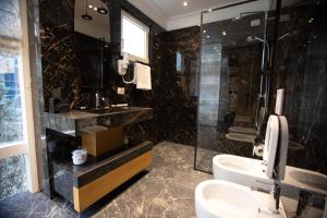 uma casa de banho com um lavatório, um chuveiro e um WC. em Seven Luxury Suites em Tirana