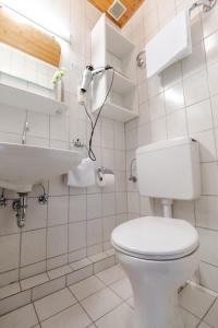 a white bathroom with a toilet and a sink at Landhotel Ewerts in Insul