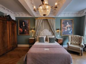 - une chambre avec un lit, un lustre et des peintures dans l'établissement Boutique Hotel Huys van Leyden, à Leyde