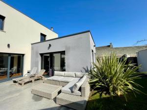 eine Terrasse mit Sofas und Stühlen vor einem Gebäude in der Unterkunft Le Boudoir in Bayeux