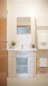 a bathroom with a white sink and a mirror at Terraço dos Rabujas in Nazaré