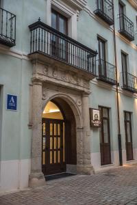 - Entrada a un edificio con puerta y balcón en PALACIO REAL HOSTEL, en León