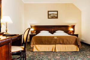 a hotel room with a bed and a desk at Turówka Hotel & Spa in Wieliczka