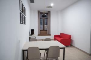 comedor con mesa y silla roja en PALACIO REAL HOSTEL, en León