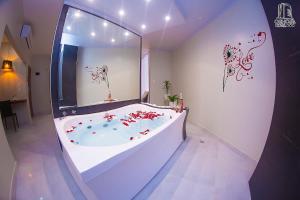 un ampio bagno con vasca e fiori di HOTEL OSHO a Santa Cruz de la Sierra