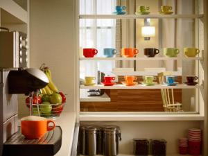 a kitchen with colorful cups and bowls on a shelf at Sonesta ES Suites Chicago - Schaumburg in Schaumburg