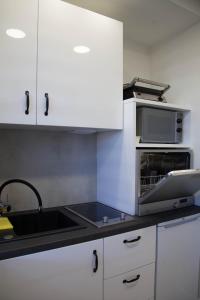 een keuken met een wastafel en een magnetron bij Apartament Wrocław Borowska in Wrocław