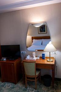 Cette chambre d'hôtel comprend un bureau avec un lit et une télévision. dans l'établissement Best Western Hotel Turist - Superior, à Skopje