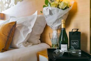 una bottiglia di champagne e un vaso di fiori su un tavolo di Aparthotel AMMI Nice Massena - ex Ajoupa a Nizza