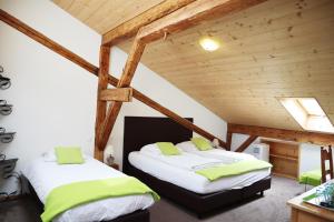 2 Betten in einem Zimmer mit Holzdecken in der Unterkunft Gruyère Rooms in Gruyères