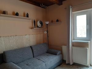 uma sala de estar com um sofá azul e uma janela em Egniss Apartman 2 em Bogács