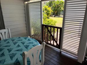 eine Veranda mit einem Tisch, Stühlen und einem Fenster in der Unterkunft la case dentelle bungalow in Le Diamant