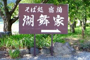 un cartel con escritura asiática en un parque en Komaya Ryokan, en Fujikawaguchiko