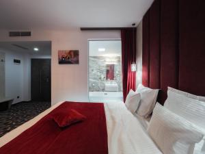 a bedroom with a large bed with a red blanket at Hotel Anastasia in Sibiu