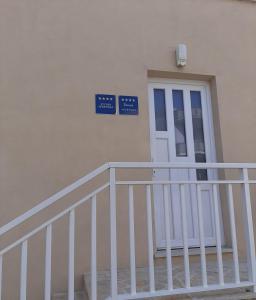 a building with a white door and a white railing at Apartmani NIKA in Dubrovnik