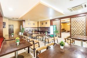 a restaurant with wooden tables and chairs at Octave Himalaya Monarch in Bangalore