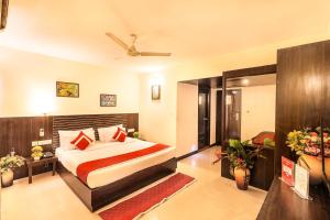 a hotel room with a bed and a ceiling fan at Octave Himalaya Monarch in Bangalore