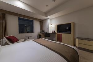 ein Hotelzimmer mit einem Bett und einem Flachbild-TV in der Unterkunft JR Kyushu Hotel Blossom Hakata Central in Fukuoka