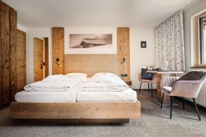 1 dormitorio con 2 camas y escritorio. en Hotel Alpenfeuer Montafon, en Sankt Gallenkirch