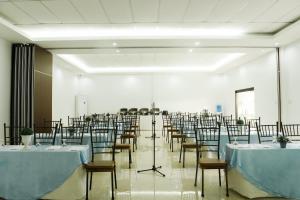 um salão de banquetes com mesas e cadeiras numa sala em Holiday Suites em Puerto Princesa