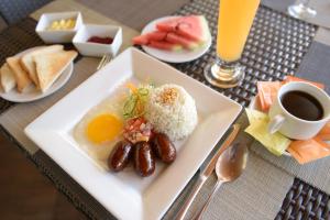 um prato de comida com arroz e ovos e uma chávena de café em Holiday Suites em Puerto Princesa