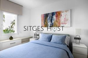 a bedroom with a blue bed and a painting on the wall at A 20 metros de la playa in Sitges