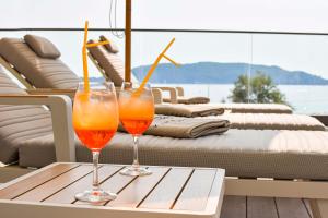 deux verres de jus d'orange assis sur une table sur un bateau dans l'établissement Katamare Hotel, à Budva