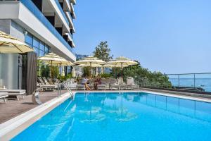 - une piscine avec des chaises et des parasols dans un bâtiment dans l'établissement Katamare Hotel, à Budva