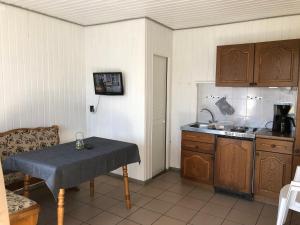 a small kitchen with a table and a sink at Gast-& Logierhaus Am Rheinsberger See in Rheinsberg