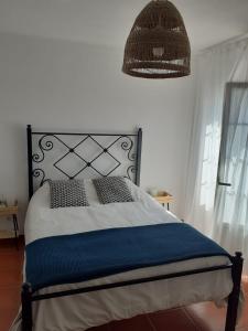 um quarto com uma cama com uma cabeceira preta e um candeeiro em Porta Reguengos - Apartamento moderno Alentejo central em Reguengos de Monsaraz