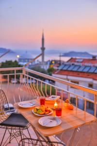 une table avec des assiettes de nourriture sur un balcon dans l'établissement Ayshe Apart, à Kaş