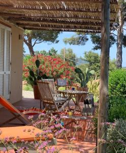 a patio with a table and chairs and flowers at La Mandorla Salata in Capoliveri