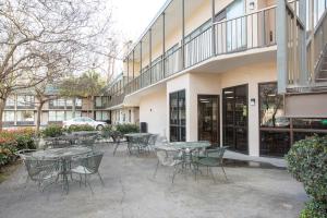 un groupe de tables et de chaises à l'extérieur d'un bâtiment dans l'établissement OYO Hotel Port Allen LA I-10 West, à Port Allen