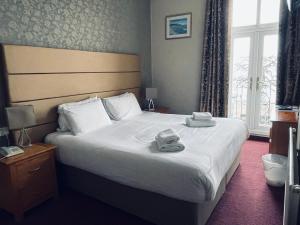 sypialnia z dużym łóżkiem z ręcznikami w obiekcie Merrion Hotel w mieście Llandudno