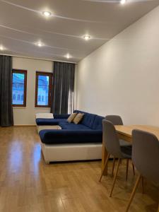 ein Wohnzimmer mit einem blauen Sofa und einem Tisch in der Unterkunft Apartmán Lara in Komárno