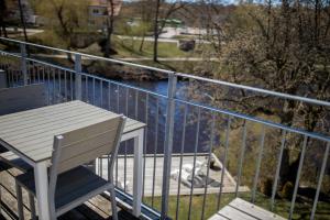 eine weiße Bank, die auf einem Balkon neben einem Wasserkörper sitzt in der Unterkunft Hotell Villa Rönne in Ängelholm