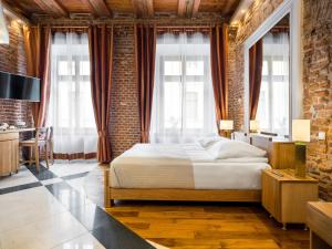 een slaapkamer met een bed en een bakstenen muur bij Aparthotel Stare Miasto in Krakau