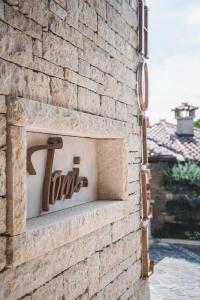 Una pared de ladrillo con un cartel. en Hotel Tomi, en Portorož