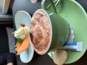 une tasse verte avec de la nourriture sur une assiette dans l'établissement Ascott Hotel & Restaurant, à Rombach