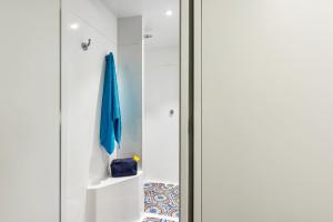 porta scorrevole in vetro in bagno con ombrello blu di hotelF1 Fréjus Roquebrune sur Argens a Roquebrune-sur Argens