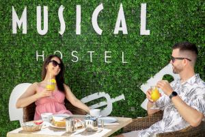 een man en een vrouw aan een tafel met drankjes bij Musical Hostel in Albufeira