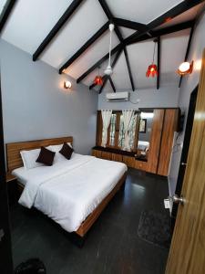 um quarto com uma grande cama branca num quarto em Raghunandan Resort em Nashik