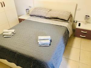 una camera da letto con un letto e asciugamani di Little house Fiera di Roma a Ponte Galeria