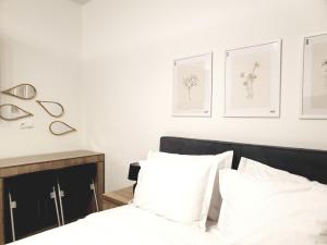 a bedroom with white walls and a bed with white pillows at Eantos Studios and Suites in Perea