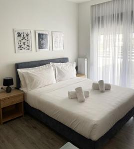 a bedroom with a large bed with white sheets and pillows at Eantos Studios and Suites in Perea