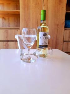 a bottle of wine sitting on a table with a wine glass at Hotel Casa Loma in Tunja