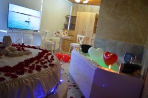 a room with a bed with hearts and a tv at Hotel Casa Loma in Tunja