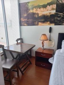 a bedroom with a table and a bed and a desk at Hotel Casa Loma in Tunja