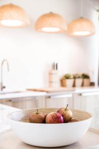 - un bol de pommes sur un comptoir dans une cuisine dans l'établissement Beach House Pedras D'el Rei, à Santa Luzia